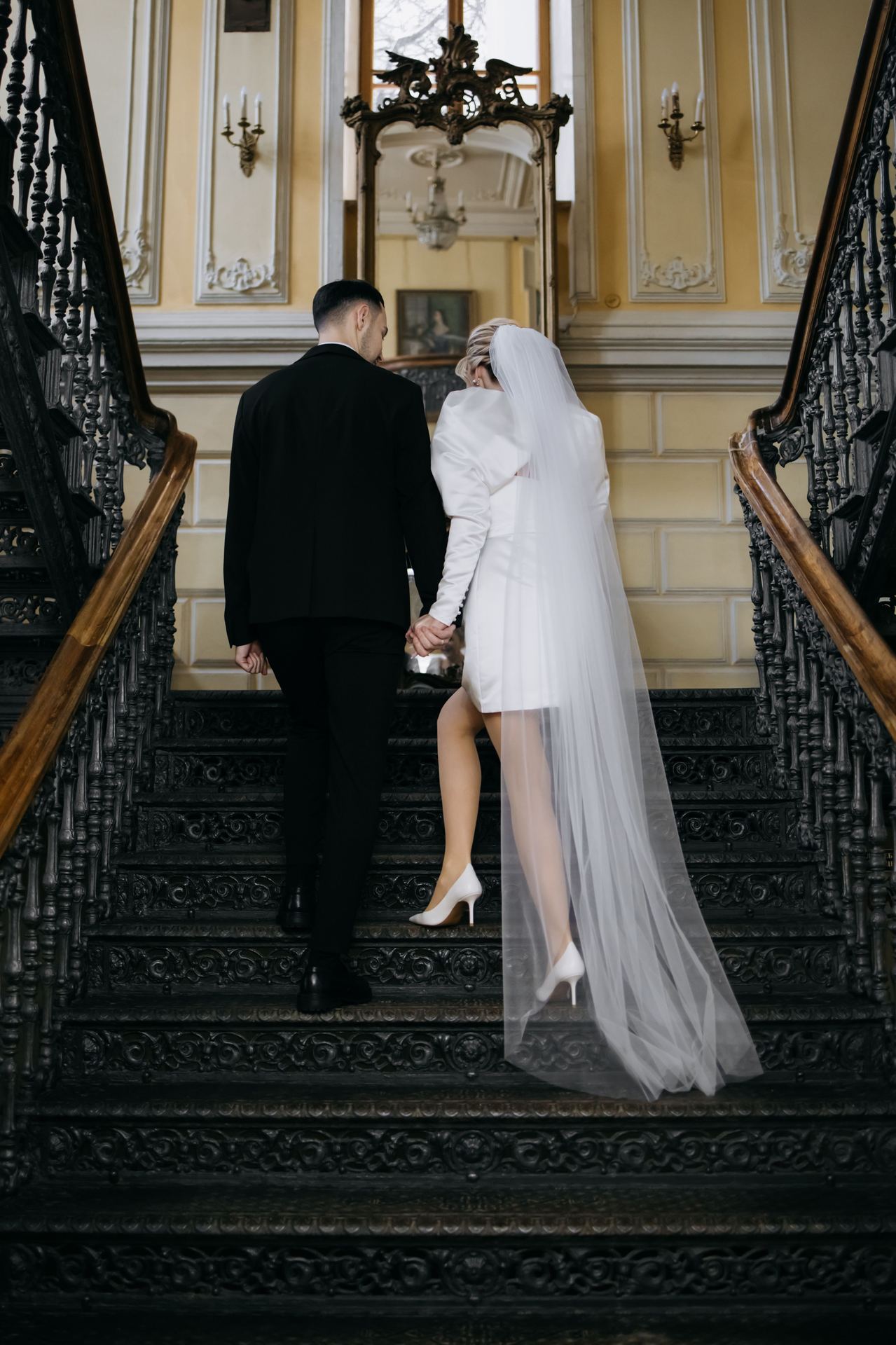 Bride and groom walking down a grand staircase